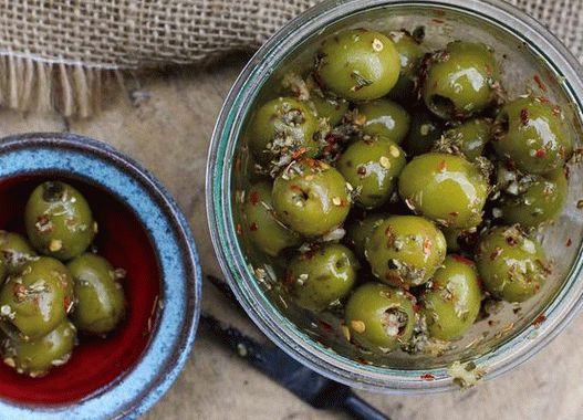 Photo Nakladené olivy s rozmarínom, červenou chilli, pomarančom a paprikou